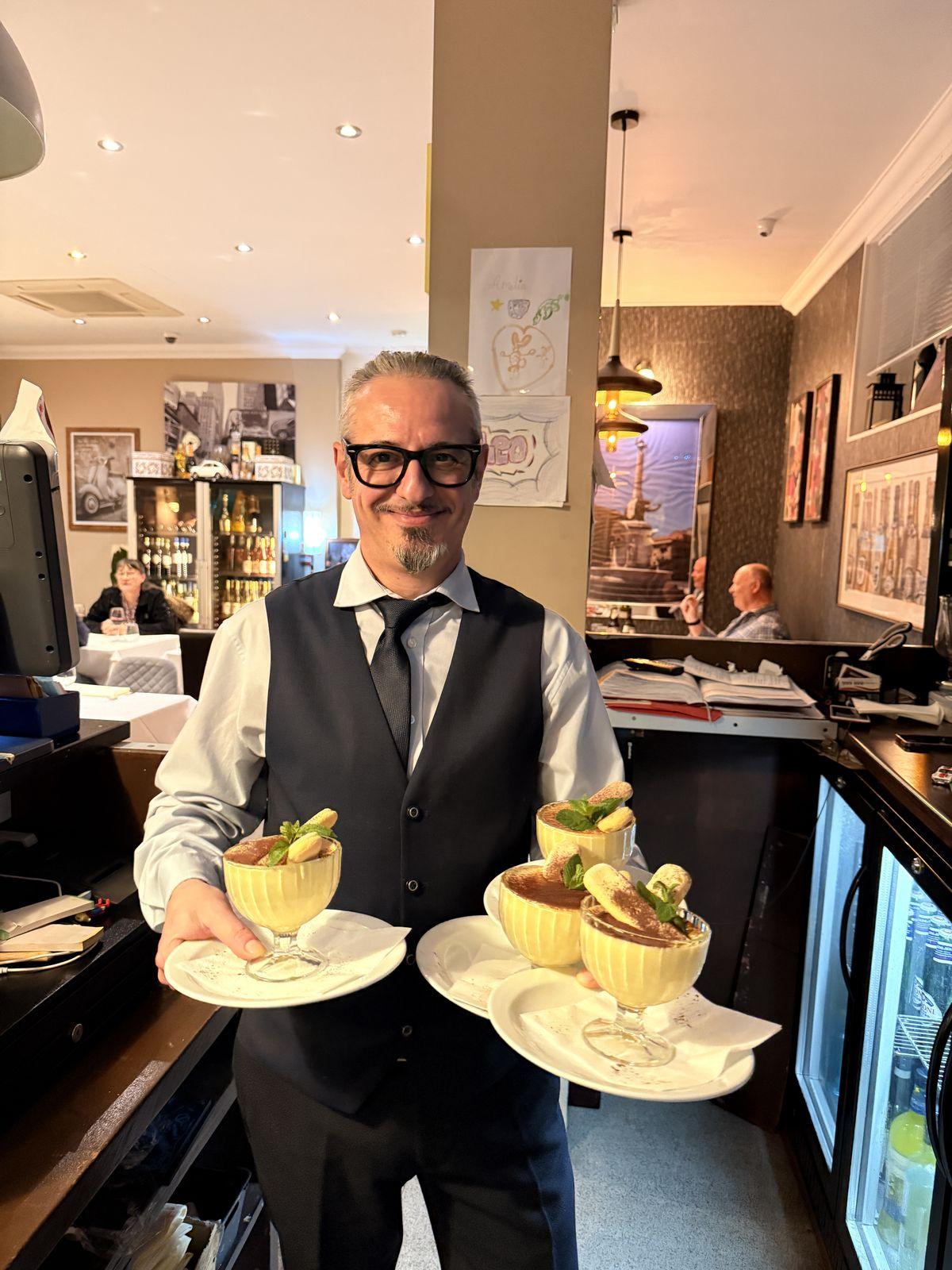 A member of the Zeno team carrying desserts to the table
