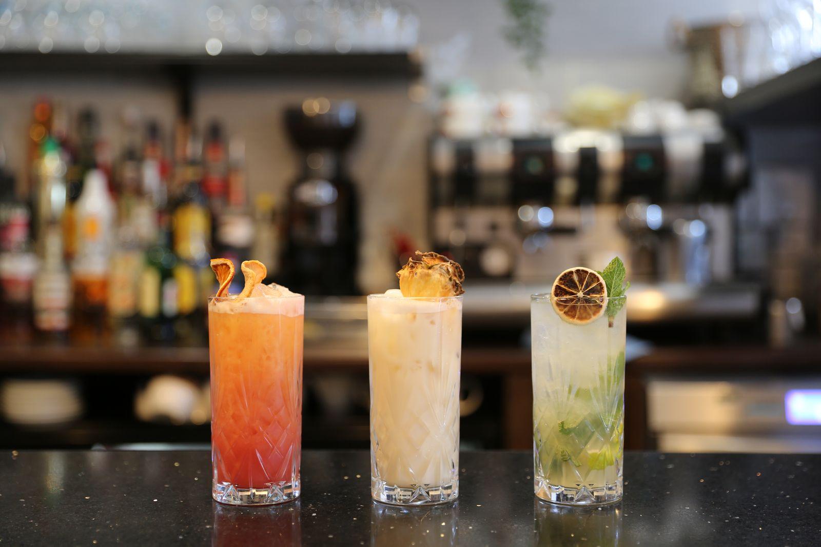 Three cocktails lined up on the bar