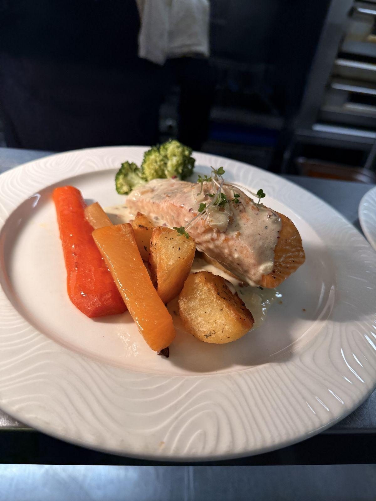 Baked salmon with roast potatoes and seasonal vegetables
