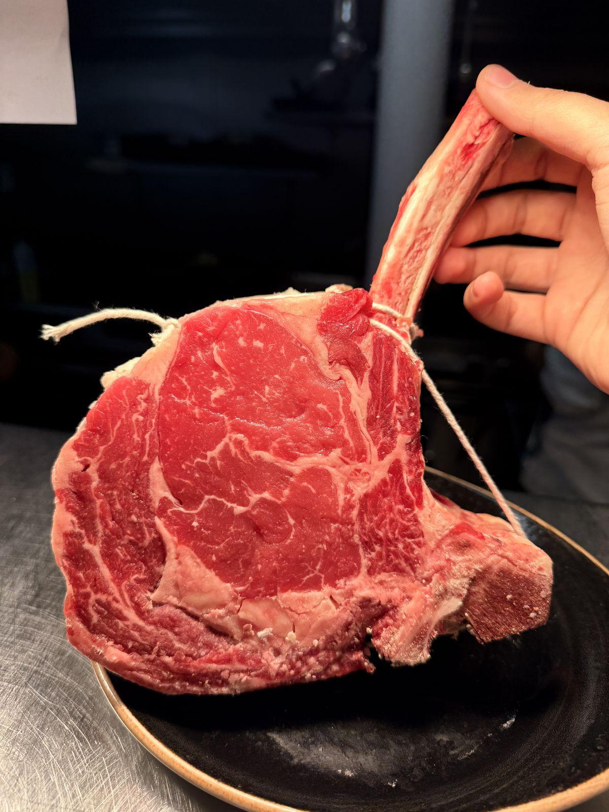 A raw bone-in tomahawk ready for the grill