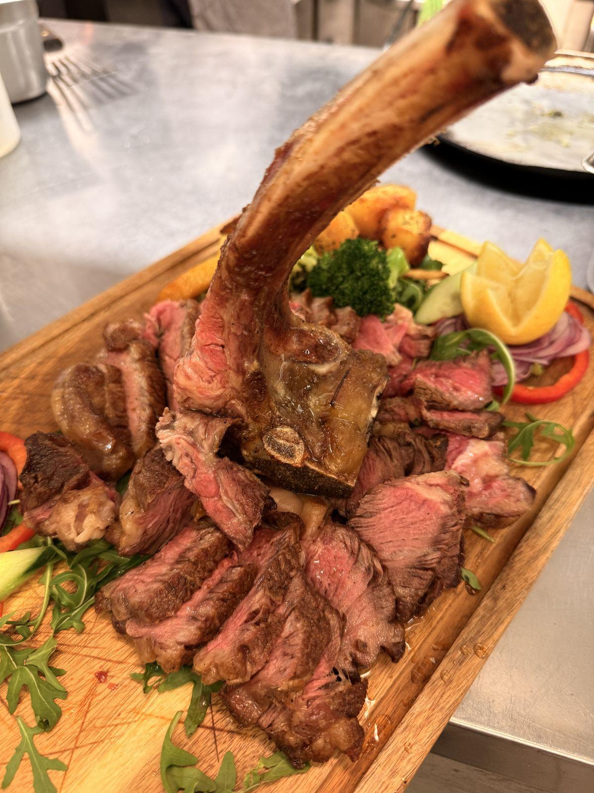 Sliced tomahawk with chips and grilled vegetables
