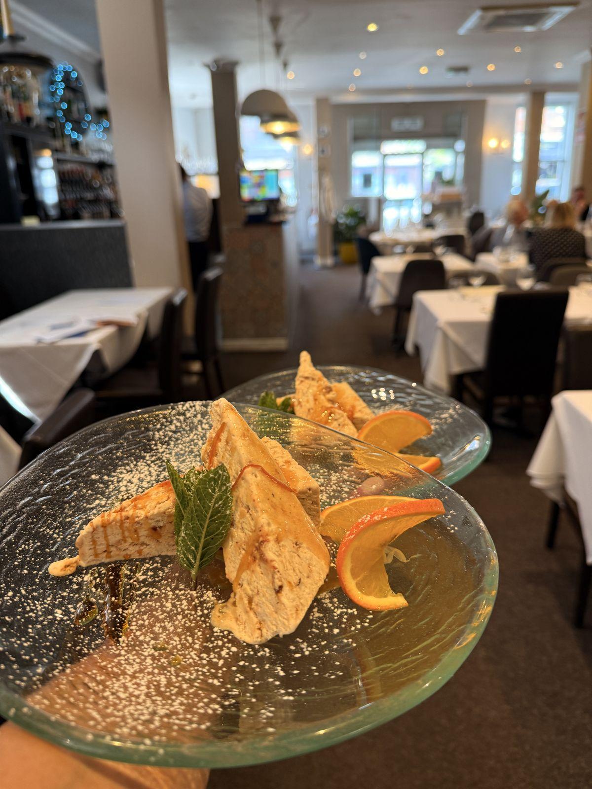 A plated dish with the dining room beyond